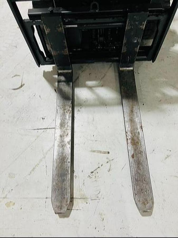 Downward view of 42" forks on refurbished 2023 Toyota 8FBE20U electric forklift showing taper profile and side shift carriage during Mississauga deployment