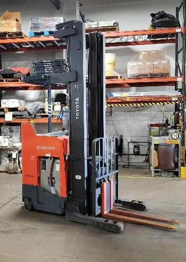 Opposite front side view of Toyota 9BRU23 single reach electric forklift shown chassis only with optional new or used battery available – CSA-certified 4,500 lb unit featuring 280” triple mast, side shift, ergonomic stand-up operator compartment, and cushion tires staged in Brampton ON – Premier Lift Equipment