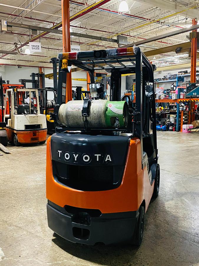 Back angle of 2019 Toyota 8FGCU20 propane forklift – CSA-certified 3,400 lb chassis showing rear counterweight, propane tank mount, and traction cushion tires with safety decals applied, Brampton ON – Premier Lift Equipment