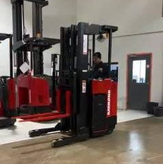 Side View: Budget Raymond reach truck showing narrow chassis and mast.