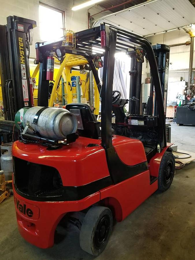 Rear side view of refurbished 2011 Yale GLP050VX LP Gas forklift showing rear chassis, solid pneumatic tires, and CSA certification decal during Ontario deployment.