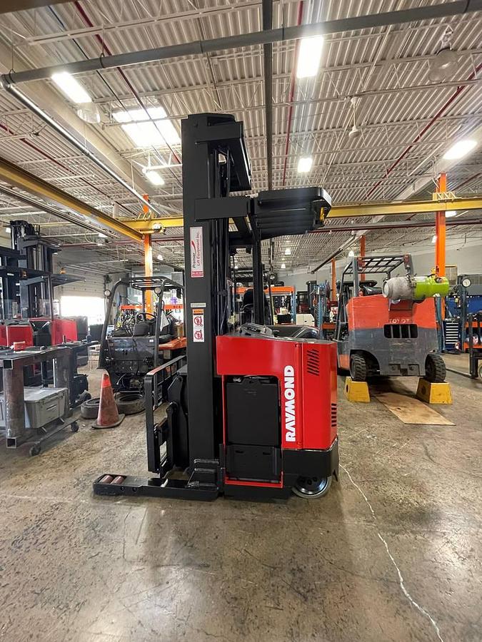 Side profile of Raymond EASI-DR25TT electric deep-reach forklift showing extended mast rails, reach mechanism, and chassis layout during Brampton deployment