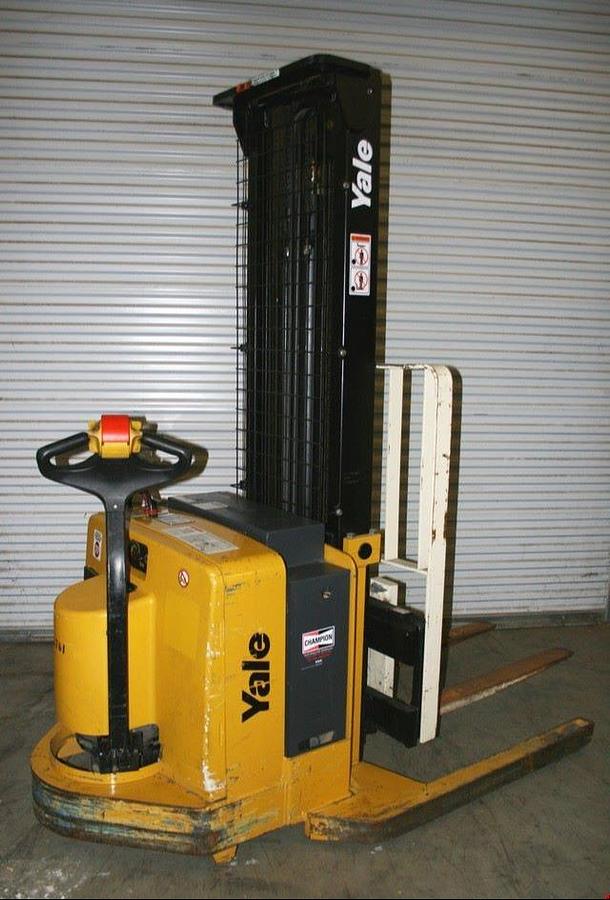 Rear angle side view of refurbished 2009 Yale MSW040 electric walkie straddle stacker showing operator handle, battery compartment, and rear wheels during Ontario deployment