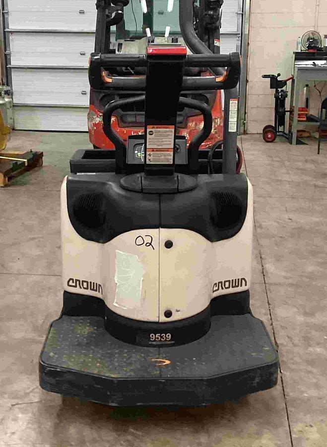 Rear view of Crown PE4500 rider pallet truck with operator platform, grab bar, and rear chassis profile.