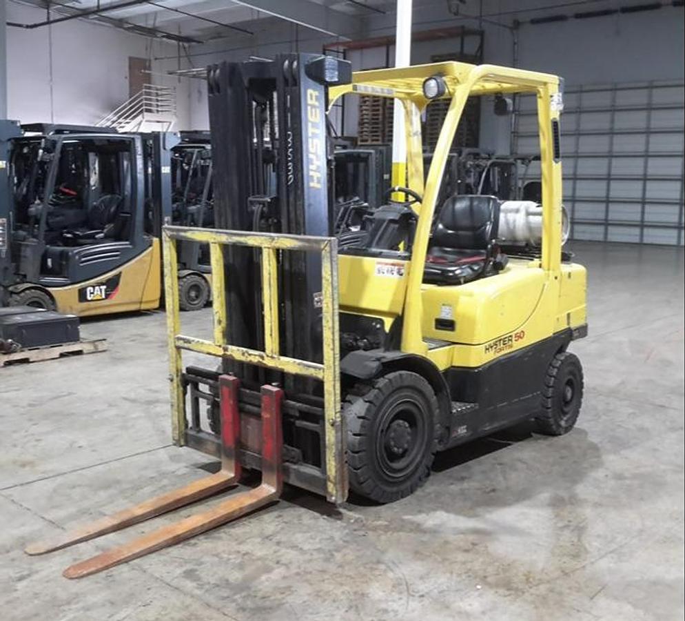 Front angled view of refurbished 2014 Hyster H50FT LP Gas forklift showing 42" forks, pneumatic tires, LPG tank, 3‑stage mast, and CSA certification decal during Brampton deployment.