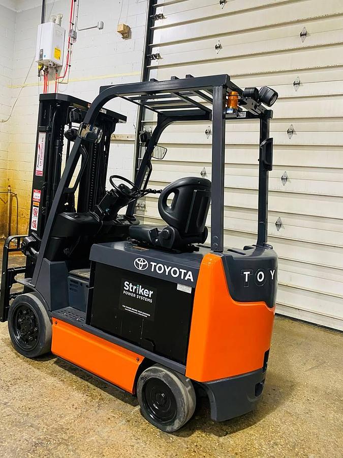 Opposite side angle view from rear to front of 2019 Toyota 8FBCU32 electric sit-down forklift showing triple-stage mast, cushion tires, battery compartment, and CSA-certified chassis – unit staged in Brampton ON