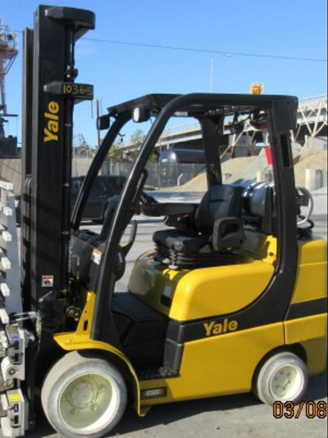 Opposite side profile of refurbished 2013 Yale GLC070VX LPG cushion forklift showing 4-way hydraulic carriage, triple mast, and cushion tires during Brampton deployment