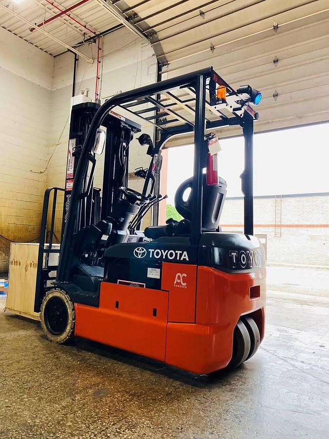 Rear angle side view of Toyota 8FBE15U 3-wheel electric sit-down forklift shown chassis only without battery – CSA-certified 3,000 lb unit featuring 189” triple mast, side shift, non-marking cushion tires, compact 36V AC chassis, and ergonomic operator station staged in Brampton ON – Premier Lift Equipment