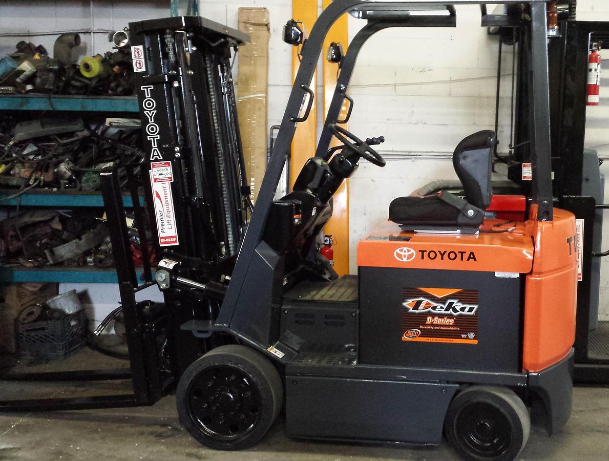Profile view of 2001 Toyota 7FBCU25 electric forklift showing 4-wheel chassis, battery compartment, and side shift carriage
