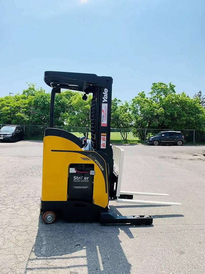 Side view of refurbished 2018 Yale NR045EB electric reach truck showing mast rails, CSA decal, and fork carriage during Ontario deployment