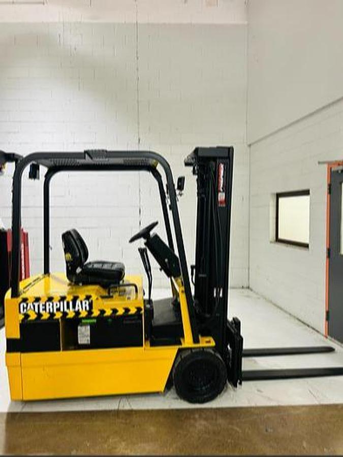 “Side view of Budget Caterpillar FC40 older 3‑wheel electric forklift, non‑CSA, includes used battery and charger.