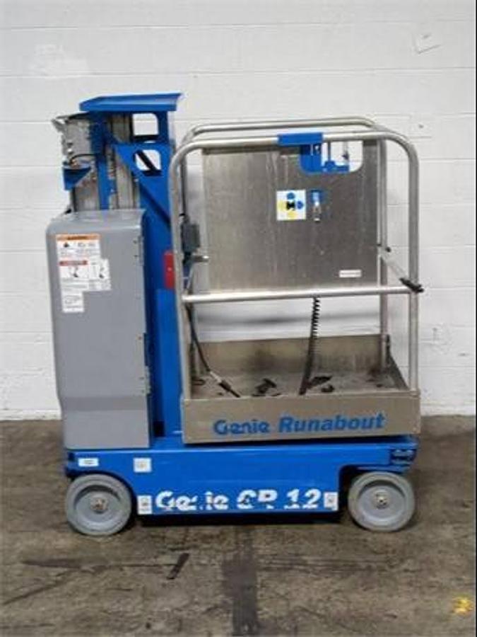 Side view of refurbished 2019 Genie GR12 electric man lift and personal lift showing vertical mast, compact chassis, and CSA certification decal during Brampton deployment.