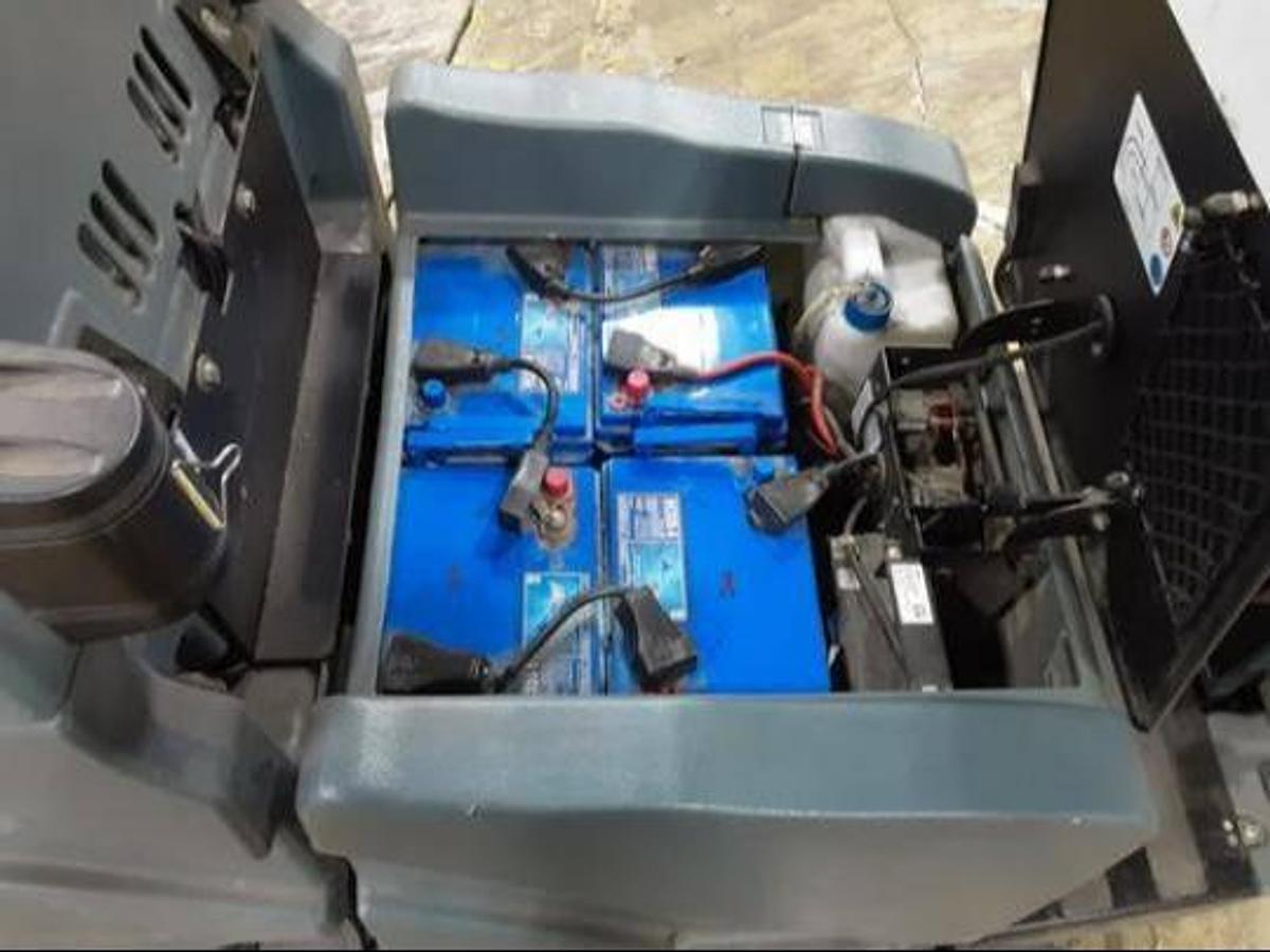 Battery compartment of refurbished 2019 Factory Cat RS25 electric rider sweeper‑scrubber showing 24 volt battery system, compatible charger connection, rear chassis housing, and CSA/MOL certification decal during Brampton deployment.