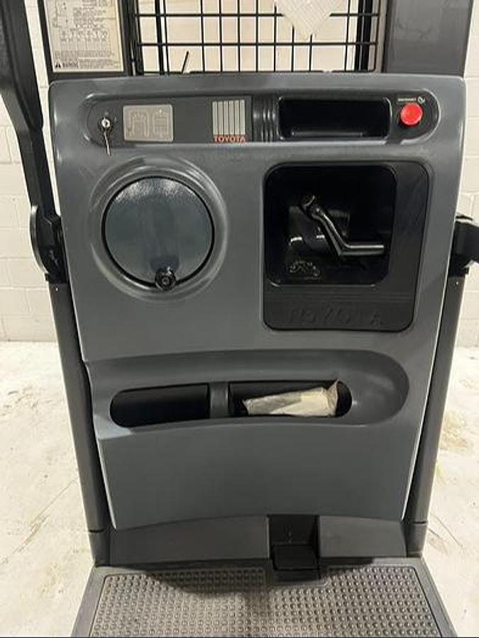 Operator compartment of Budget Toyota 7BPUE15 order picker showing platform, controls, and guard rails.