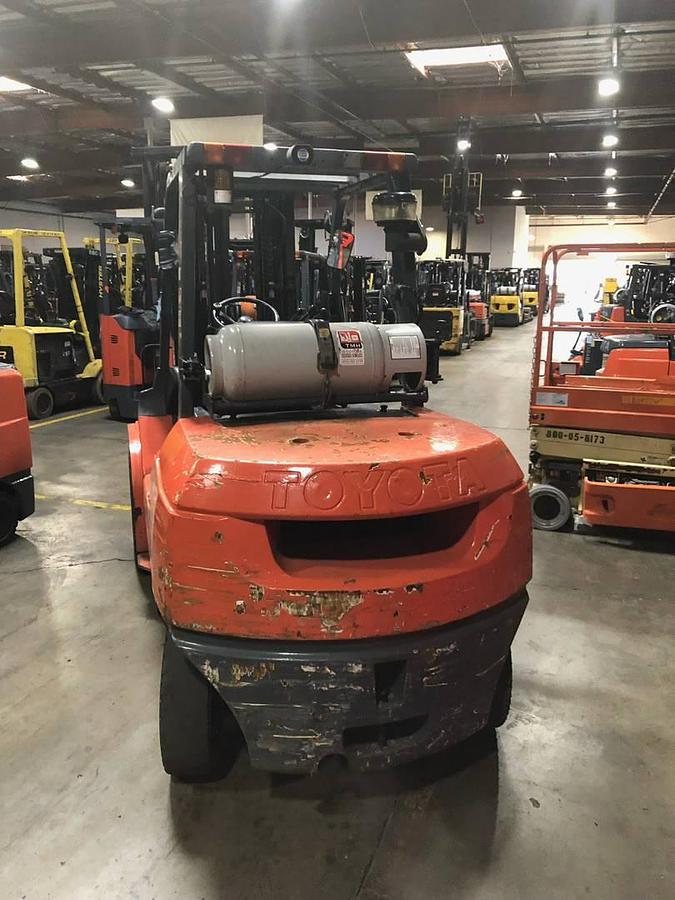 Back view of refurbished 2013 Toyota 7FGU45 LP gas forklift showing counterweight, propane tank mount, and CSA inspection tag during Brampton deployment