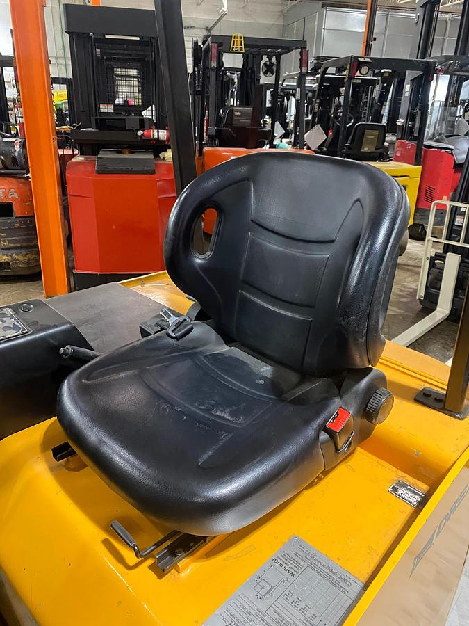 Operator seat of Drexel SLT30 electric swing mast forklift showing padded seat, hip restraints, and CSA-certified cab – unit staged in Brampton ON