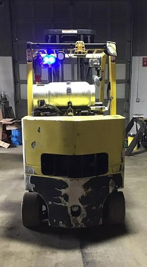 Rear view of refurbished 2015 Hyster S120FTPRS LPG cushion forklift showing counterweight, rear tires, and propane tank bracket during Brampton deployment