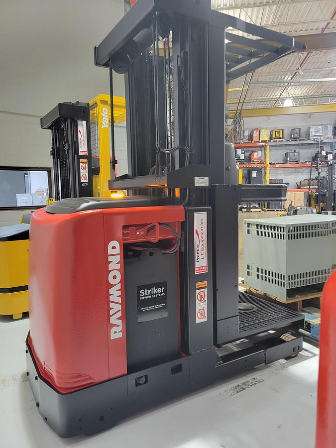 Side view of refurbished 2006 Raymond 520-OPC30TT electric order picker showing battery compartment, chassis frame, and platform base during Mississauga deployment
