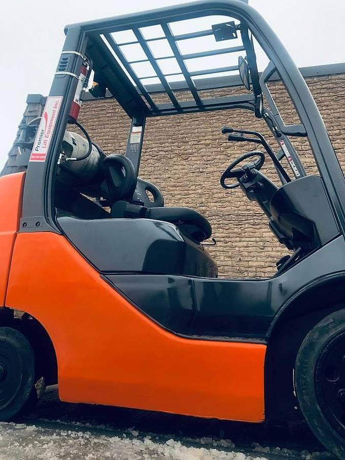 Opposite side view of refurbished 2018 Toyota 8FGCU25 LPG cushion forklift showing truckers mast, side shift carriage, operator cab, and 80" lift height during Brampton deployment