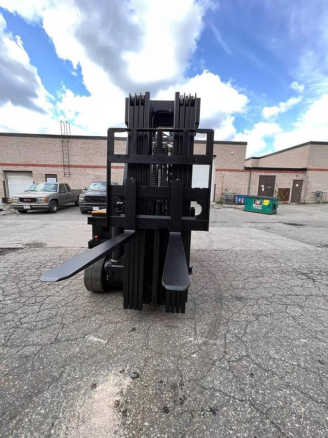 Head-on view of refurbished 2017 Drexel SL-40AC electric SwingMast forklift showing 89" collapsed quad mast, forks, base legs, and operator cab with CSA safety decals during Brampton deployment