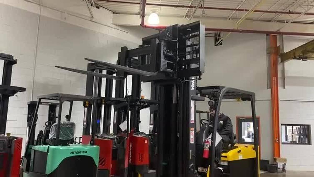 Front view of refurbished 2014 Yale ERC080VHN electric cushion tire forklift with forks raised, showing mast extension, swing mast rails, and CSA certification decal during U.S. deployment.