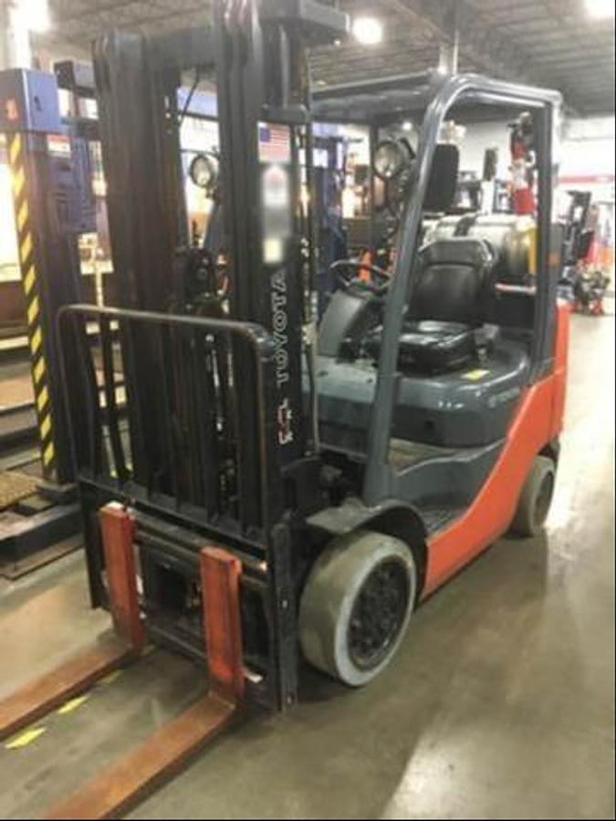 Front side view of refurbished 2014 Toyota 8FGCU25 LP gas forklift showing triple mast, 42" forks, and non-marking cushion tires during Brampton deployment