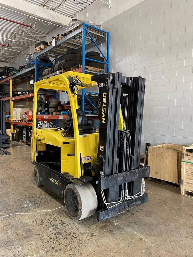 Front side view of refurbished 2019 Hyster E120XN electric forklift showing 83"/169" triple mast, forks, solid tires, and CSA certification decal during Ontario deployment.