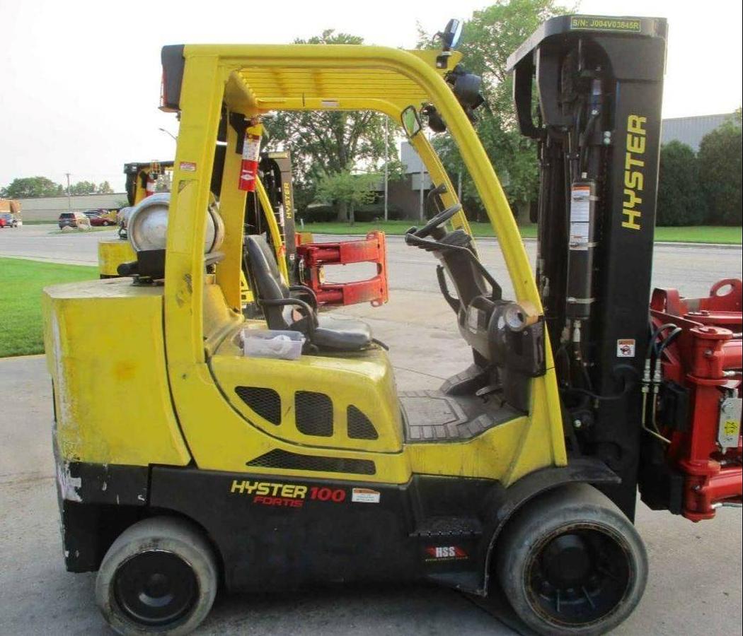 Side view of refurbished 2018 Hyster S100FT‑BCS LP Gas forklift showing solid tires, Auramo Balzoni paper roll clamp, and CSA certification decal during Ontario deployment.