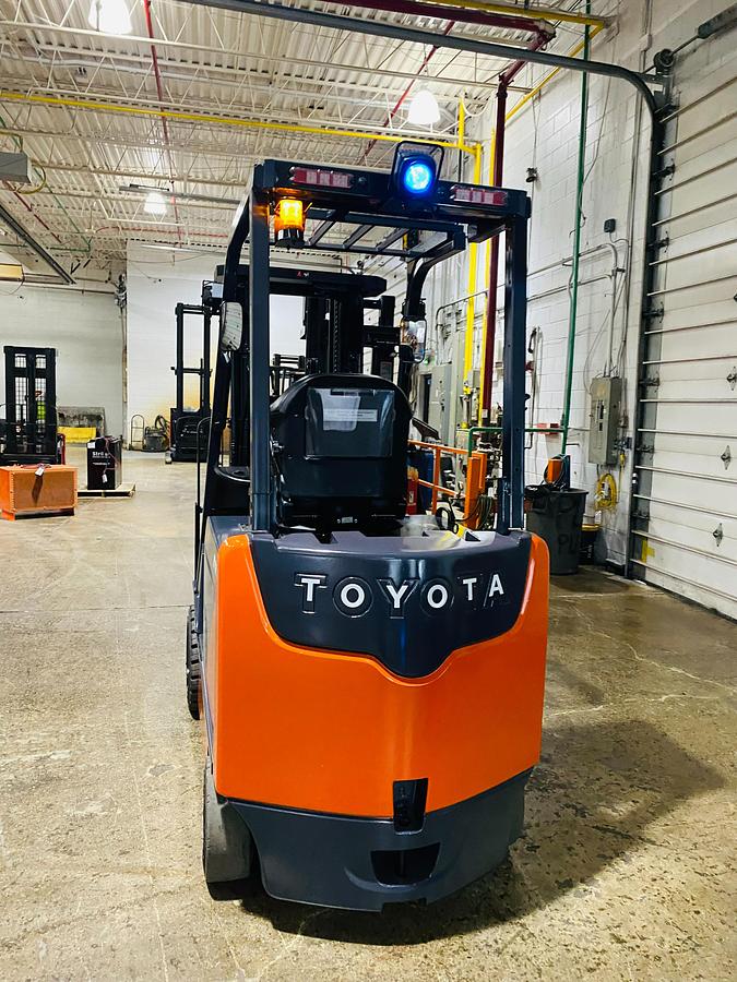 Rear view of Toyota 8FBCU32-EE electric forklift highlighting counterweight, EE decals, and CSA certification during warehouse deployment