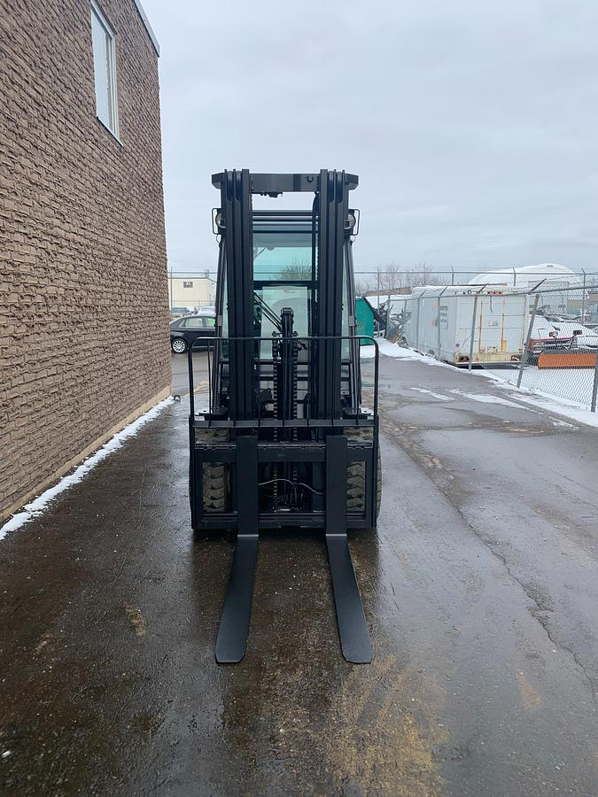 Front view of refurbished 2013 Toyota 8FGU30 LP gas forklift showing mast, carriage, and solid pneumatic tires during Brampton deployment