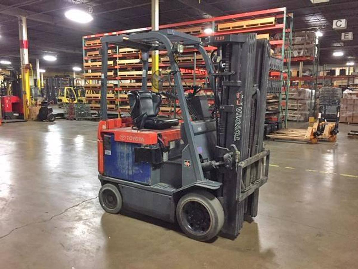 Side view of refurbished 2005 Toyota 7BCU20 electric 4-wheel sit-down forklift showing quad mast, CSA decal, and 4-way hydraulic lines during Ontario deployment