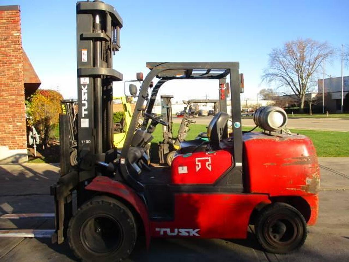 Opposite side view of Tusk 1100PGA2‑8 propane forklift showing LP gas tank, pneumatic tires, and CSA compliance markings during Brampton deployment