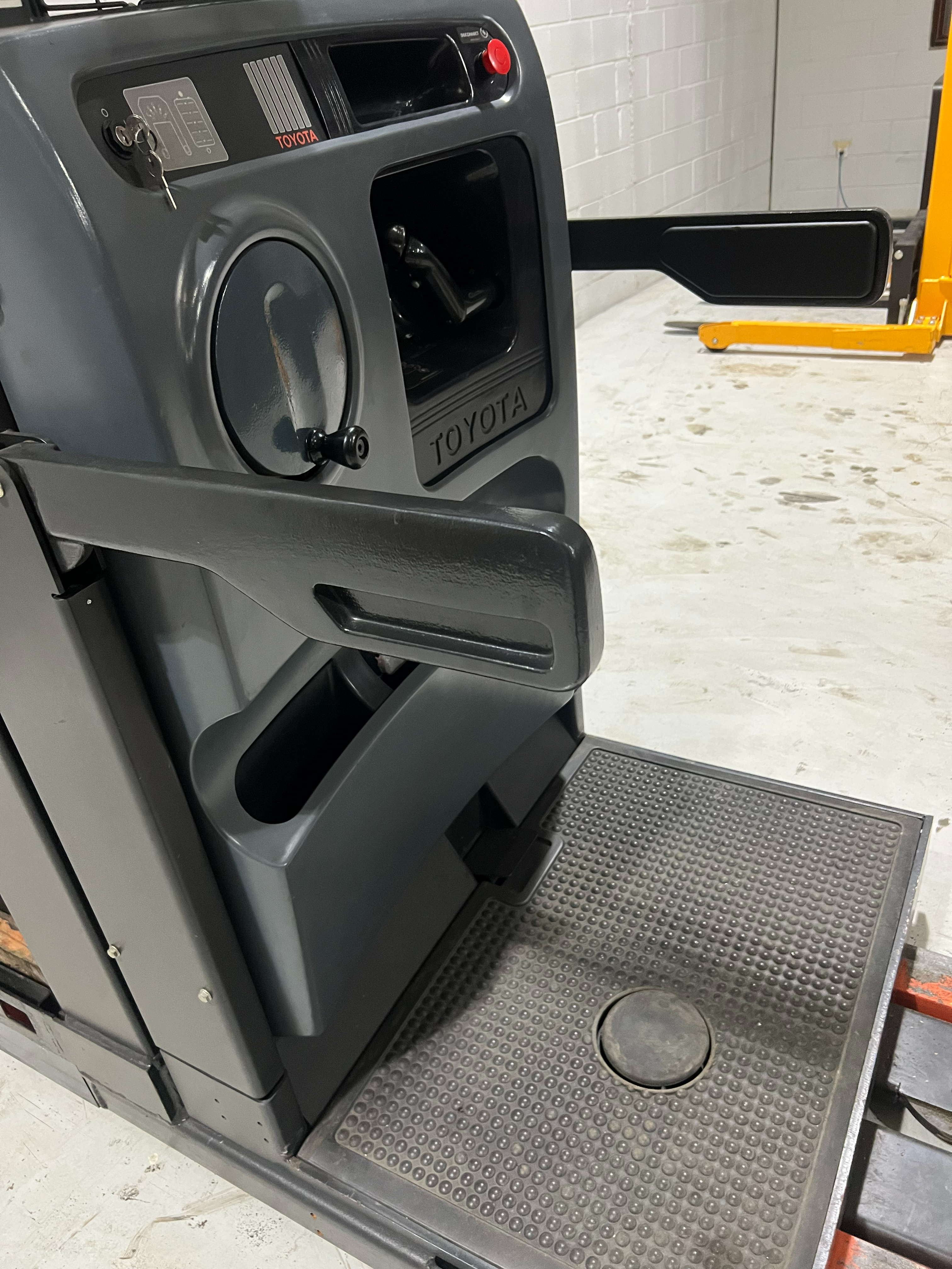 Angled operator view of Budget Toyota 7BPUE15 order picker showing safety arms and platform guard system.