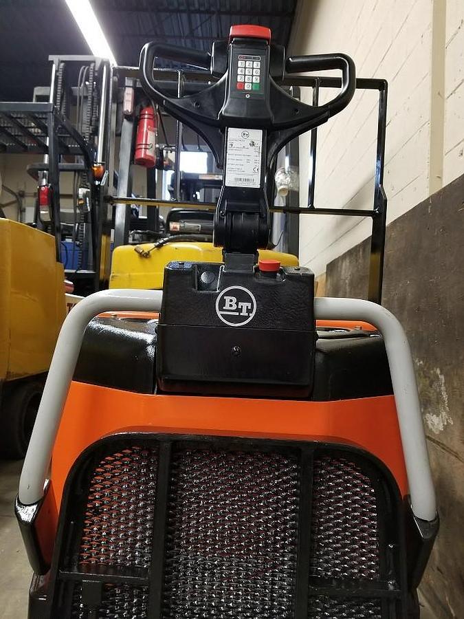 Flip‑down operator platform of refurbished 2011 BT LPE200/8 electric walkie/rider pallet jack shown in the up position, secured against chassis, with 27" x 45" forks and CSA certification decal during Ontario deployment.