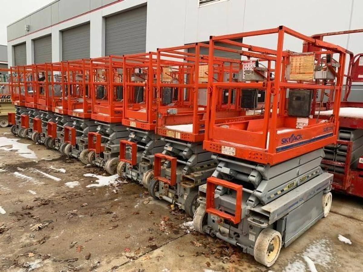 Front angled view of refurbished 2015 Skyjack SJ3219 electric scissor lift showing platform rails, 25 ft working height, 24 volt chassis, built‑in charger, and CSA certification decal during Brampton deployment.