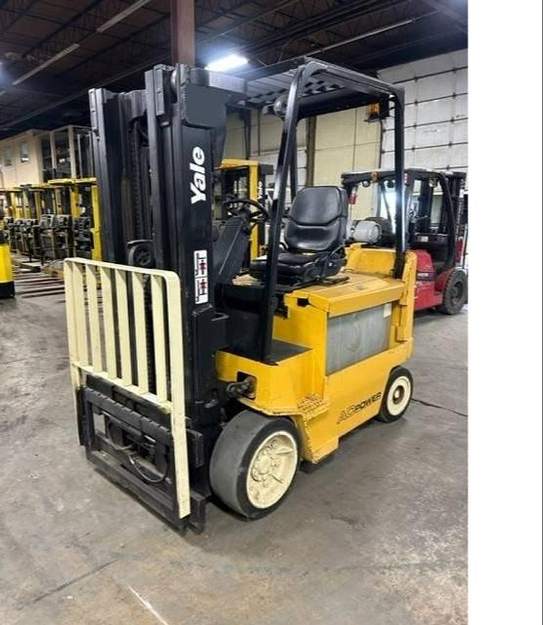 Opposite front side view of refurbished 2011 Yale ERC080HHN electric forklift showing mast, forks, operator cab, and cushion tire chassis during Brampton deployment