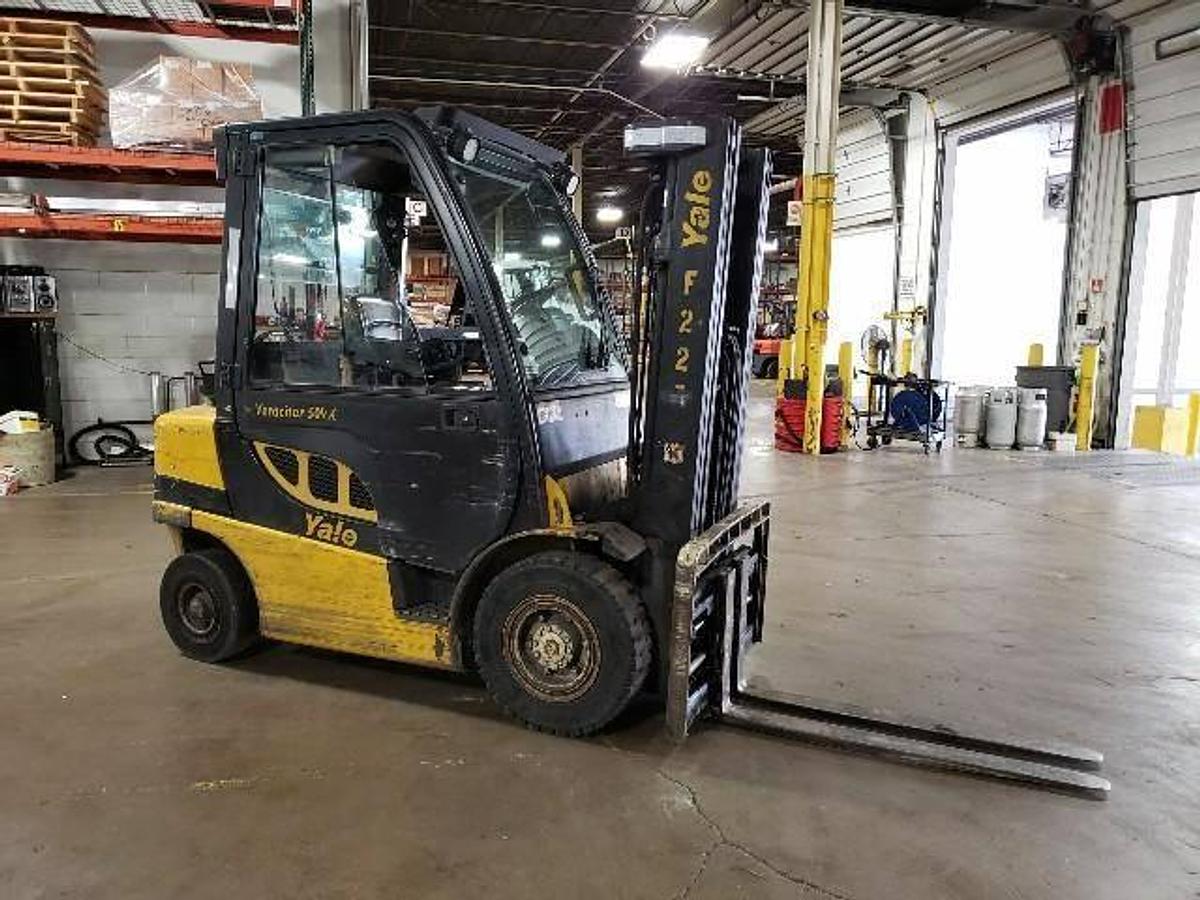 Side profile of 2014 Yale GLP050VX LPG pneumatic forklift showing mast rails, cab enclosure, and chassis layout during Brampton deployment