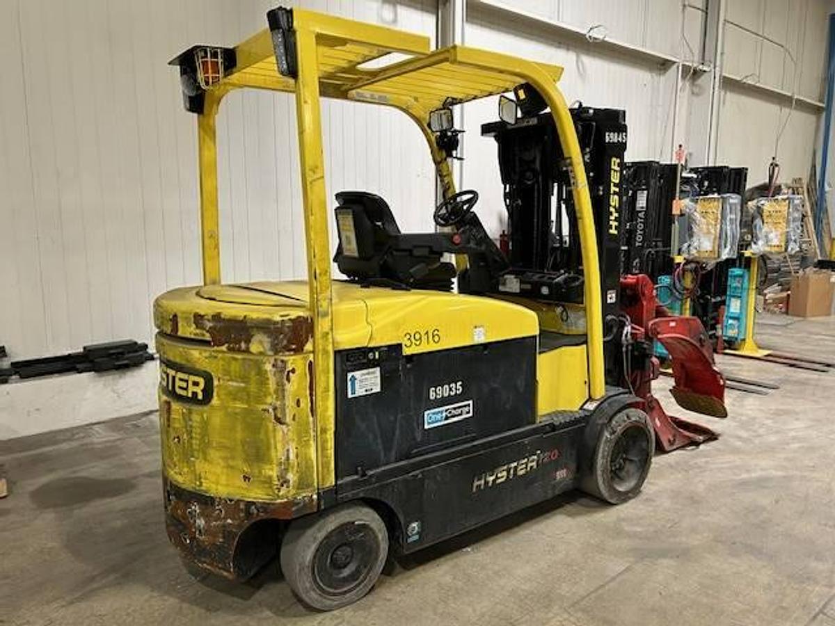 Opposite rear side view of refurbished 2019 Hyster E120XN electric forklift showing counterweight, cab enclosure, non‑marking tires, and CSA certification decal during Ontario deployment.