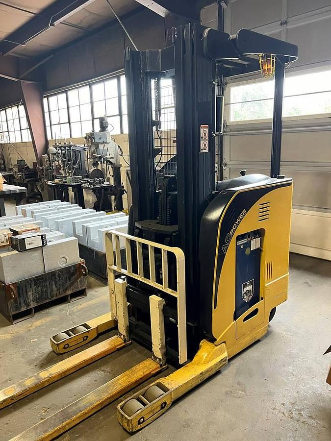 Front angle side view of refurbished 2007 Yale NR040DANS24TE091 electric reach truck showing fork tips, mast rails, and CSA certification decal during Ontario deployment