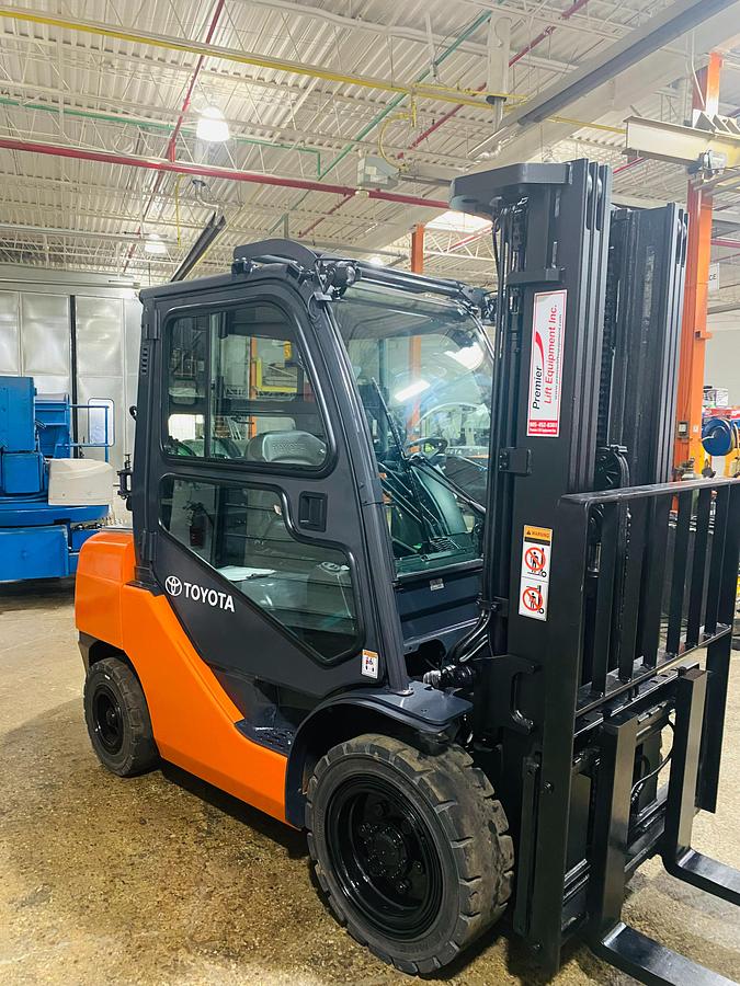 Side view of refurbished 2013 Toyota 8FGU30 LP gas forklift showing full cab, chassis, and triple mast during Brampton deployment