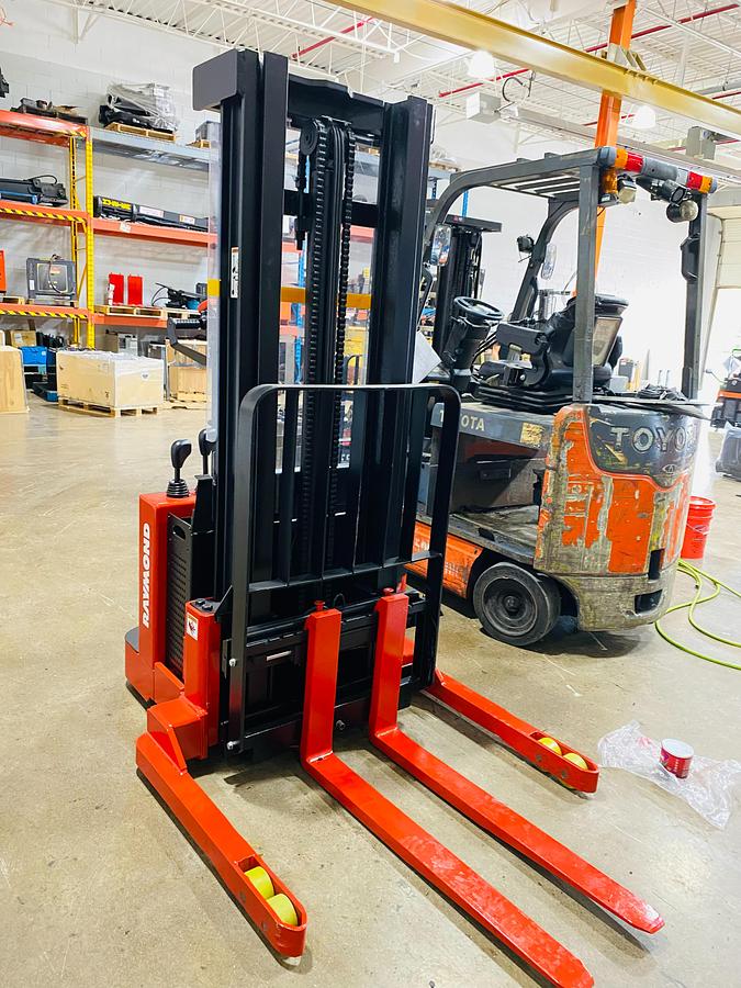 Front view of refurbished 2003 Raymond DSX40 electric walkie straddle stacker showing 42" base leg opening and 48" outside base width during Ontario deployment