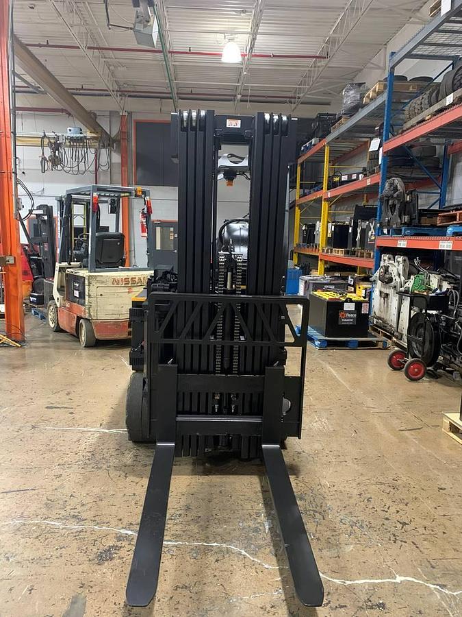 Head-on view of refurbished 2017 Drexel SL-40AC electric SwingMast forklift showing base legs, 250" quad mast, forks, and operator cab with CSA safety decals during Brampton deployment