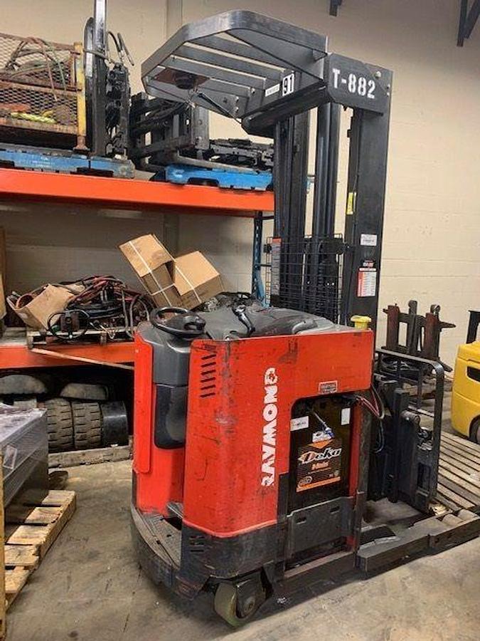 Side view of refurbished 2002 Raymond EASIR35TT electric reach truck showing battery compartment, chassis frame, and 33" base legs during Oakville deployment