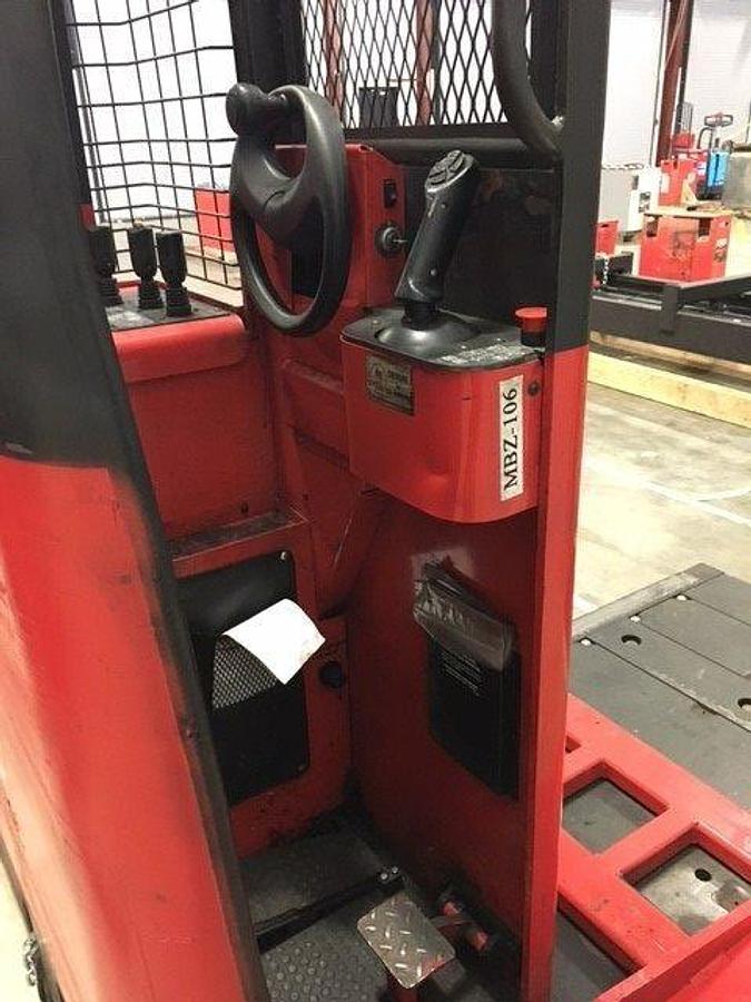 Operator compartment of 2012 Raymond 9300-SL60TN electric sideloader showing steering wheel, instrument cluster, and CSA safety decals during Brampton deployment