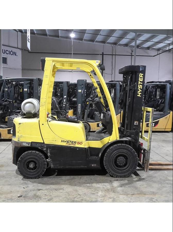 Side view of refurbished 2014 Hyster H50FT LP Gas forklift showing pneumatic tires, 4‑wheel sit‑down chassis, and CSA certification decal during Brampton deployment.