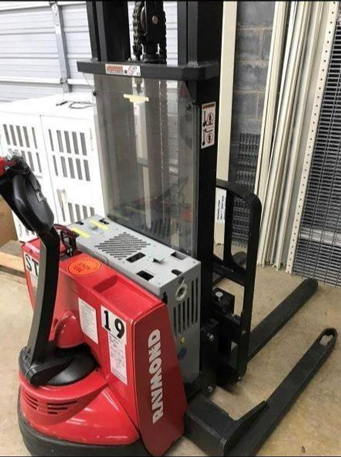 Rear side angle view of refurbished 2013 Raymond RSS40 electric walkie straddle stacker showing tiller arm, control head, battery compartment, and CSA decal during Ontario deployment