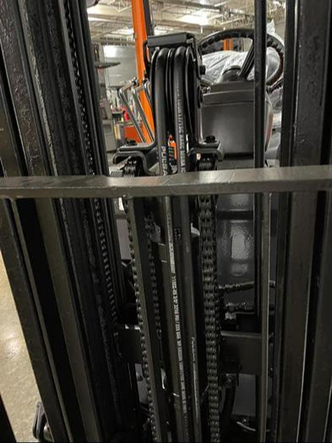 Close-up of 2019 Toyota 7FBCU18 electric forklift mast assembly – CSA-certified triple-stage mast with tilt cylinders, load backrest extension, and clamp-ready hydraulic lines shown reconditioned with used 36V battery option in Brampton ON – Premier Lift Equipment