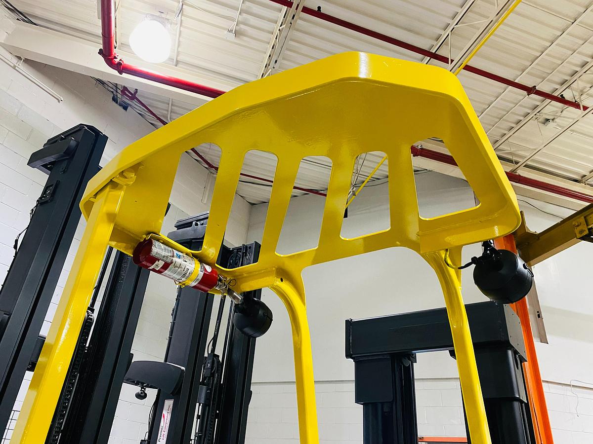 Upward view of overhead guard on Hyster E30FR-24 electric dockstocker showing welded steel canopy, operator clearance zone, and CSA-compliant safety structure – unit staged in Brampton ON