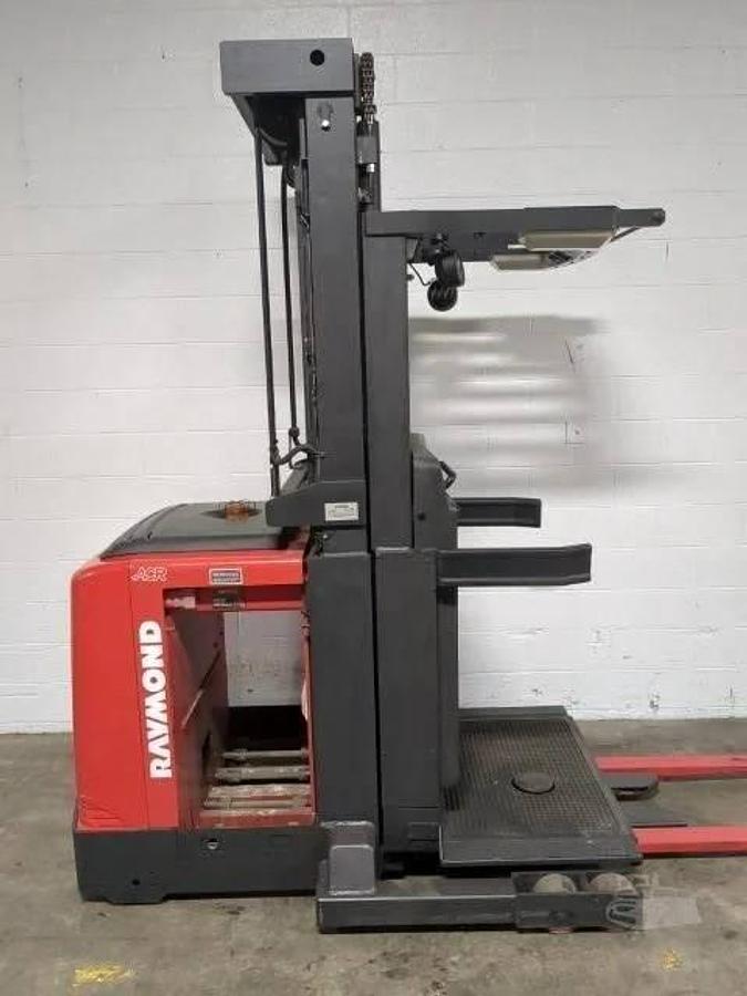 Side view of refurbished 2014 Raymond 560-OPC30TT electric order picker showing narrow aisle chassis, battery compartment, and platform base during Vaughan deployment