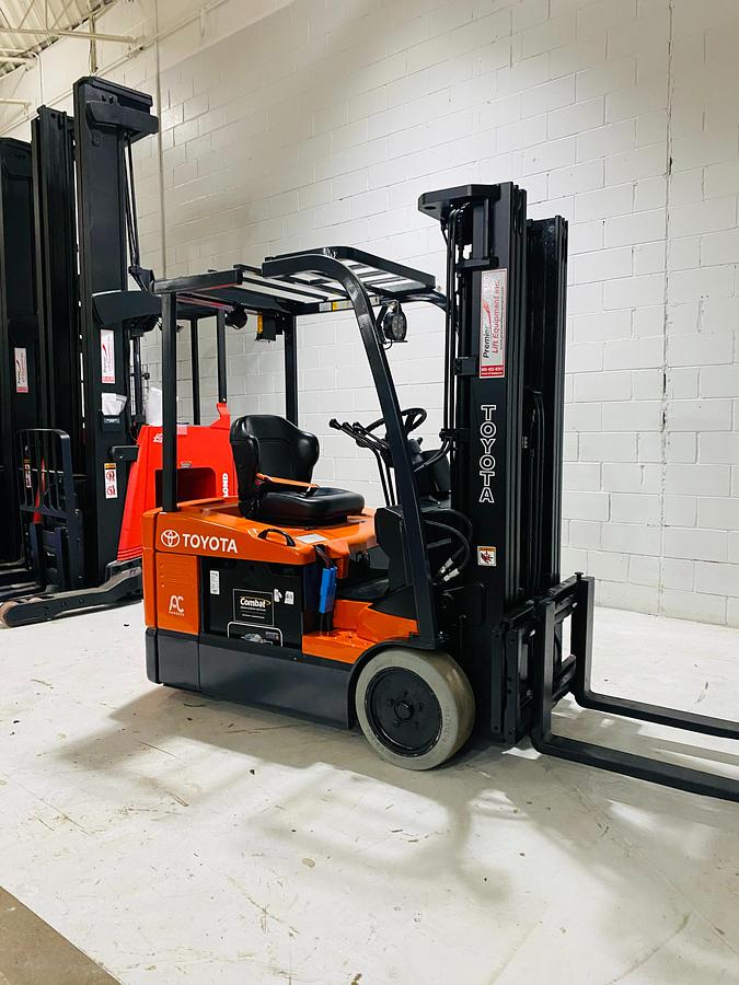 Front angle view of 2015 Toyota 7FBEU15 electric forklift showing extended forks, triple-stage mast, load backrest, and CSA-certified chassis – unit staged in GTA ON
